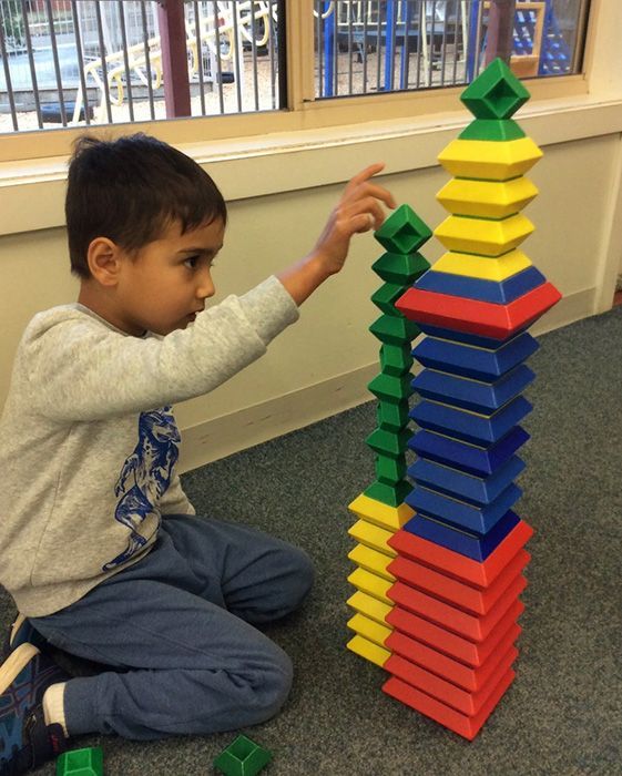 A kindergarten child building with colourful blocks at A.C.E